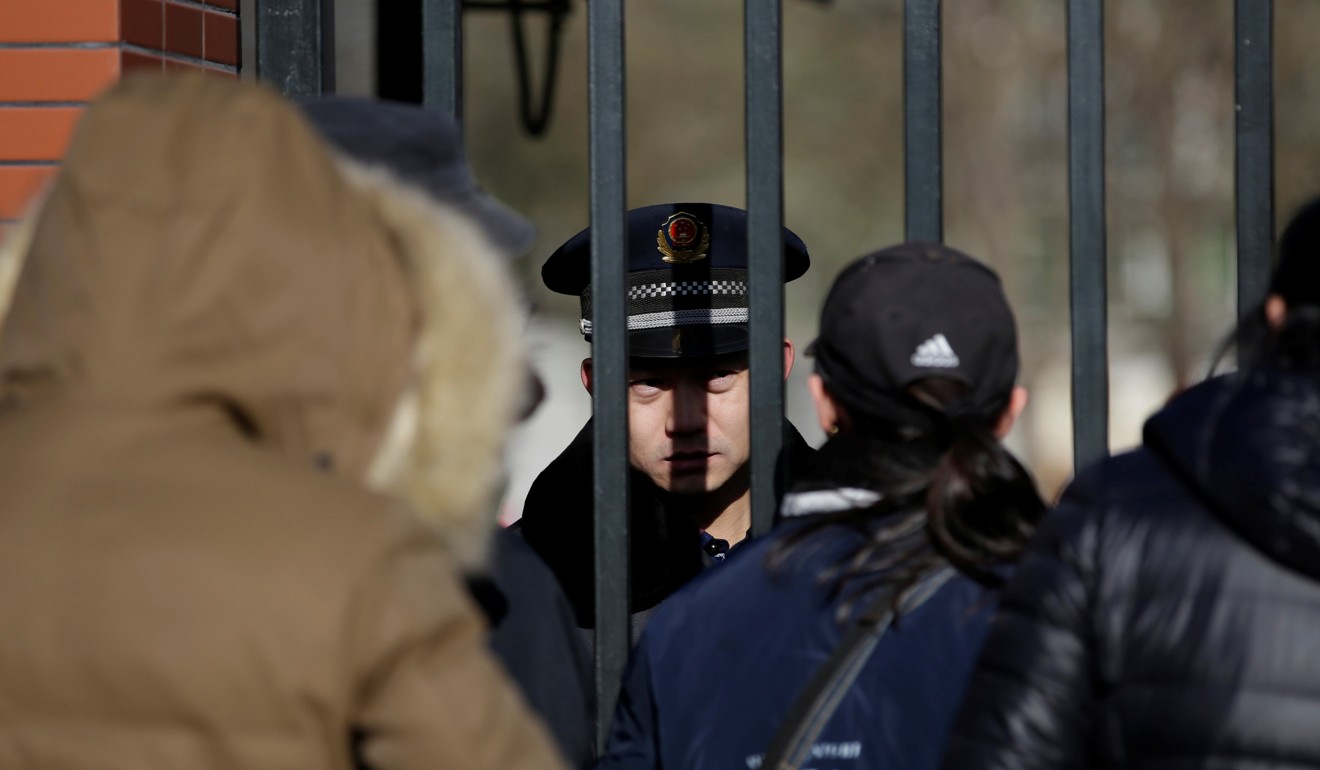 A security guard talks to parents at the gate of the kindergarten run by preschool operator RYB Education being investigated by China's police, in Beijing. Photo: Reuters