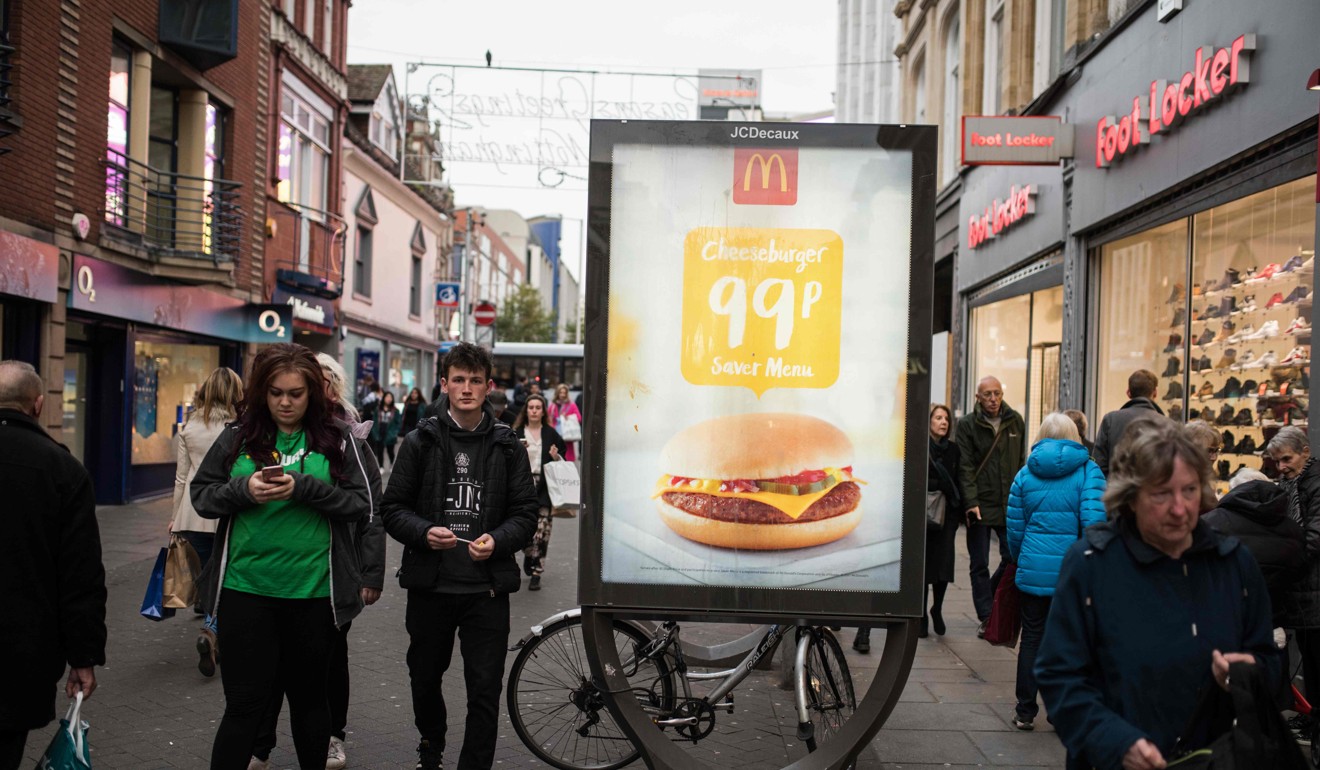 Pedestrians pass an by an ad for fast food chain McDonald's in Nottingham, England. Photo: AFP
