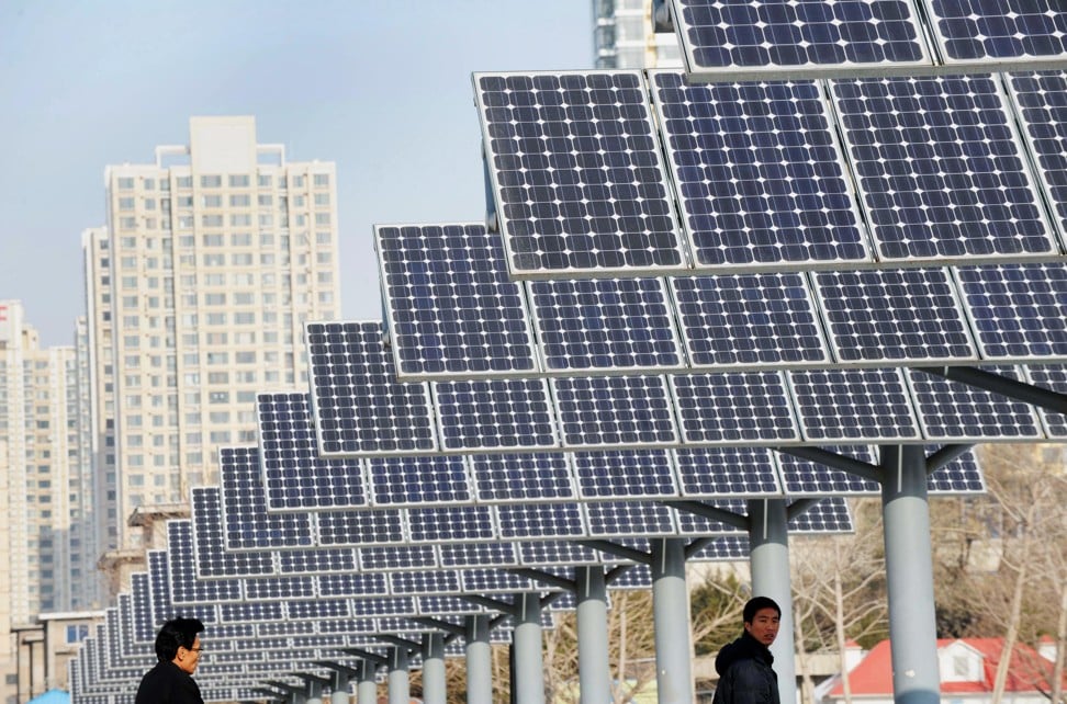 People walk past a line of solar power panels in Shenyang, northeastern China. Despite its efforts to curb its coal use, Beijing is expected to record a 3.5 per cent rise in carbon emissions this year. Photo: AFP