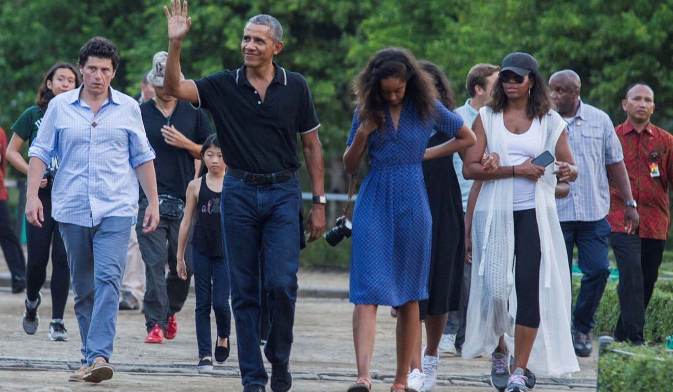 Former US president Barack Obama waves while walking with his daughter Malia and his wife Michelle during a family holiday to Indonesia in June. Photo: Reuters
