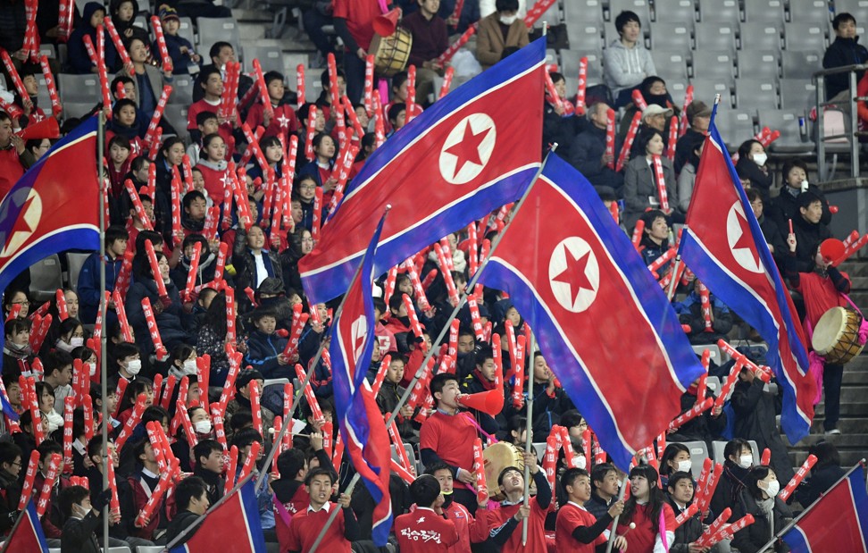 Supporters cheer for the North Korean soccer team during the match between China and North Korea. Photo: EPA