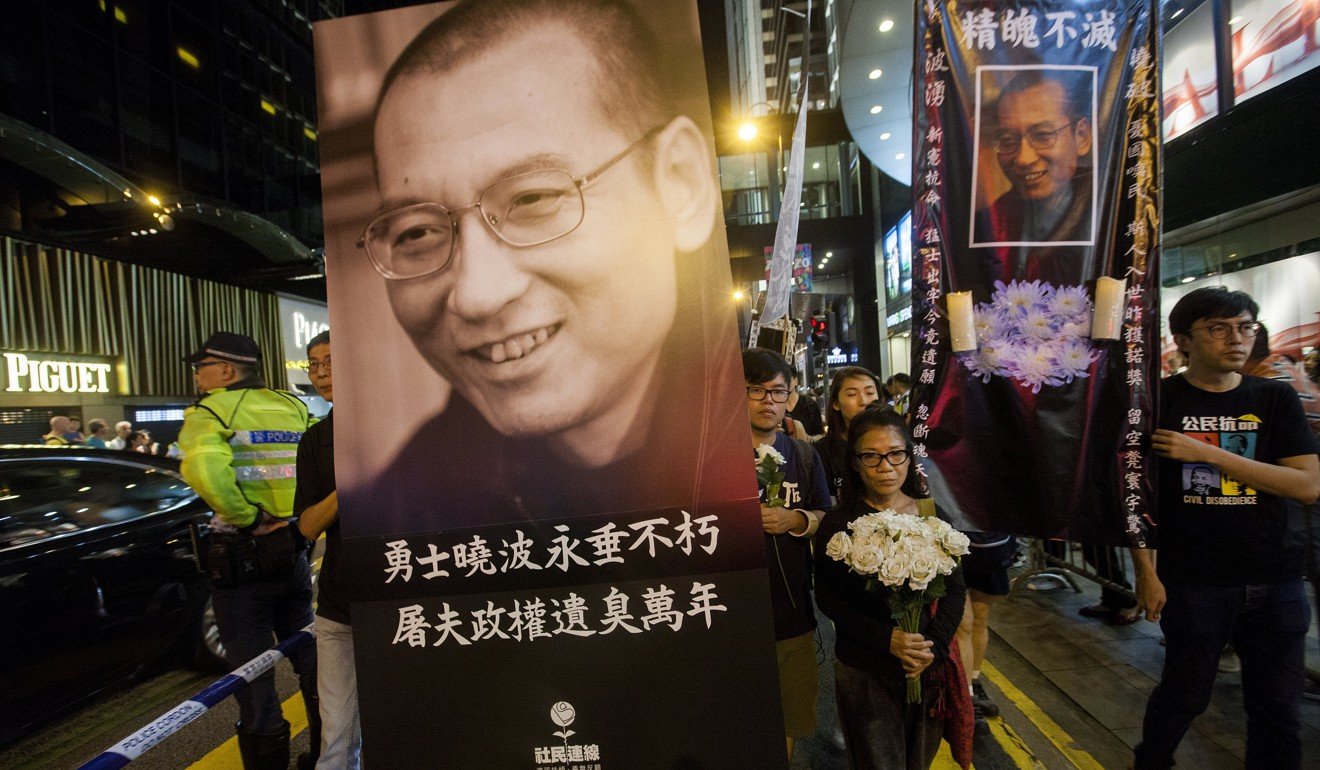 Members of the League of Social Democrats hold a portrait of the deceased Chinese dissident and Nobel laureate Liu Xiaobo, as they march through the streets of Hong Kong. Photo: EPA