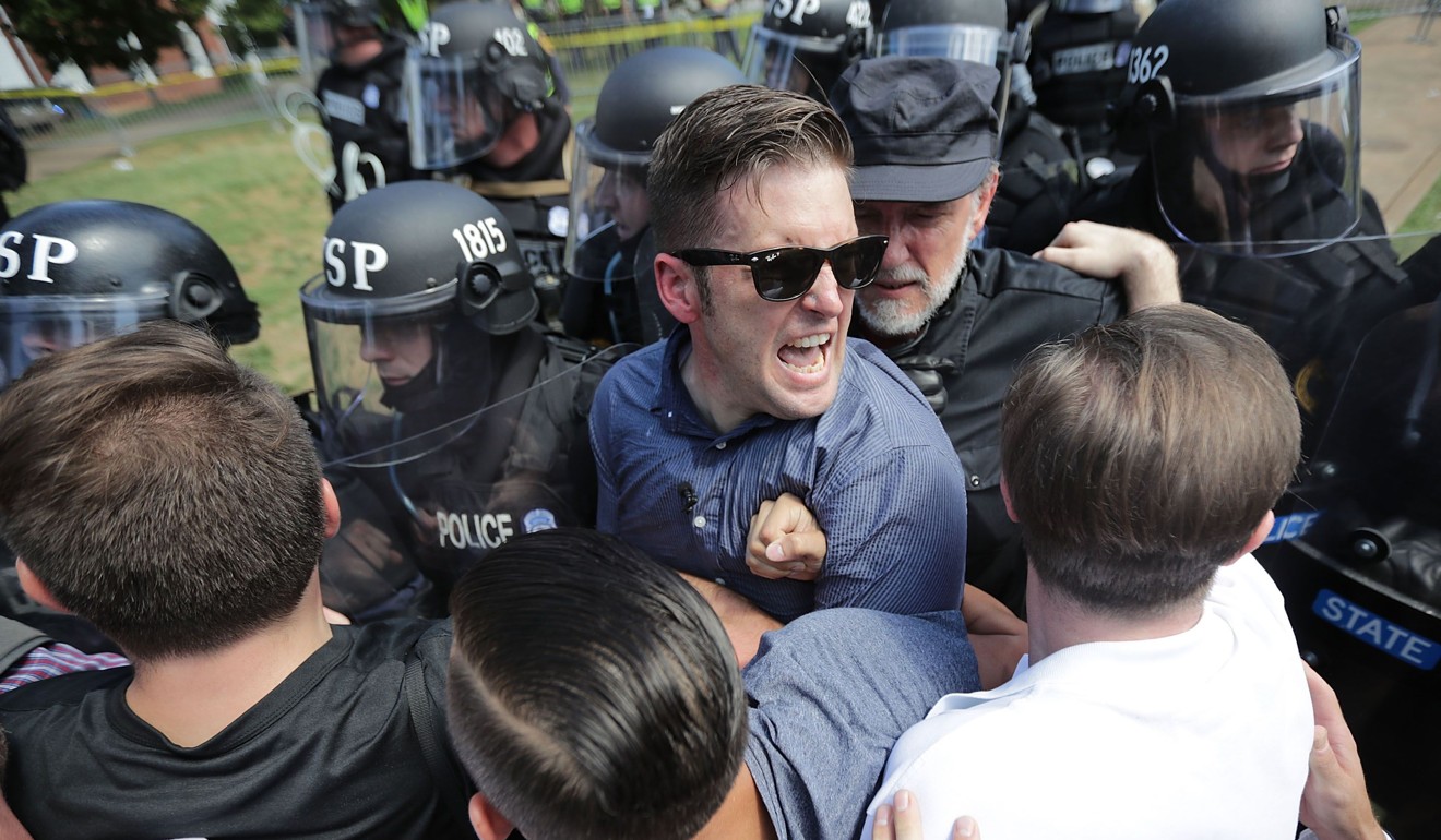 White nationalist Richard Spencer (C) and his supporters clash with Virginia State Police in Emancipation Park after the “Unite the Right” rally was declared an unlawful gathering August 12, 2017 in Charlottesville, Virginia. Spencer’s Twitter account was not suspended, but other white nationalist accounts were blacked out. Photo: Getty Images/AFP