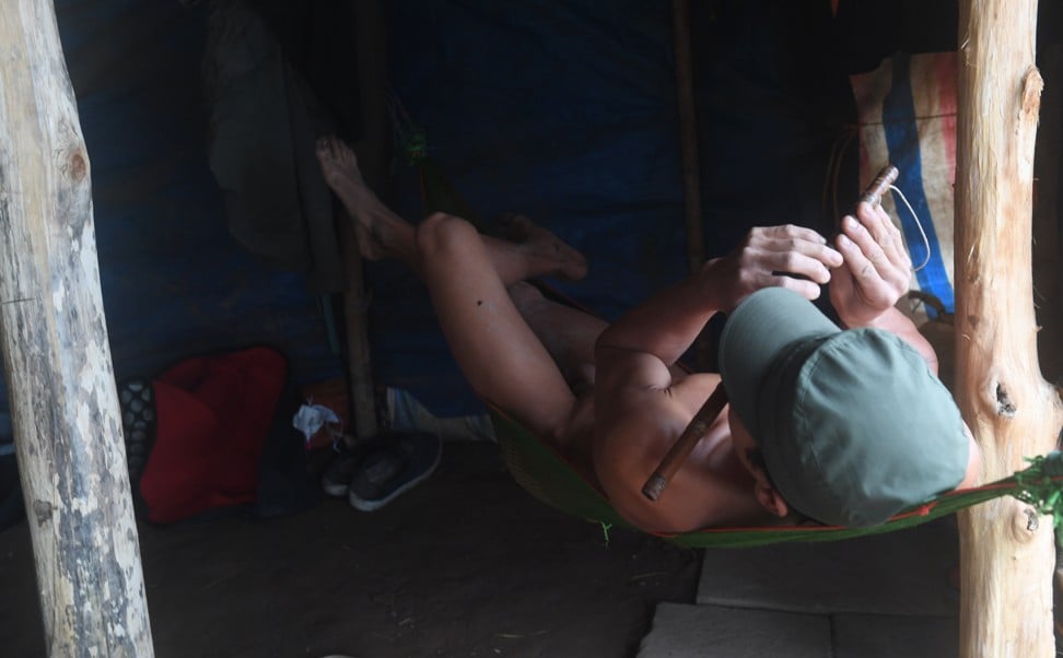 A nudist plays a flute in a hut by the southern banks of the Red River. Photo: AFP