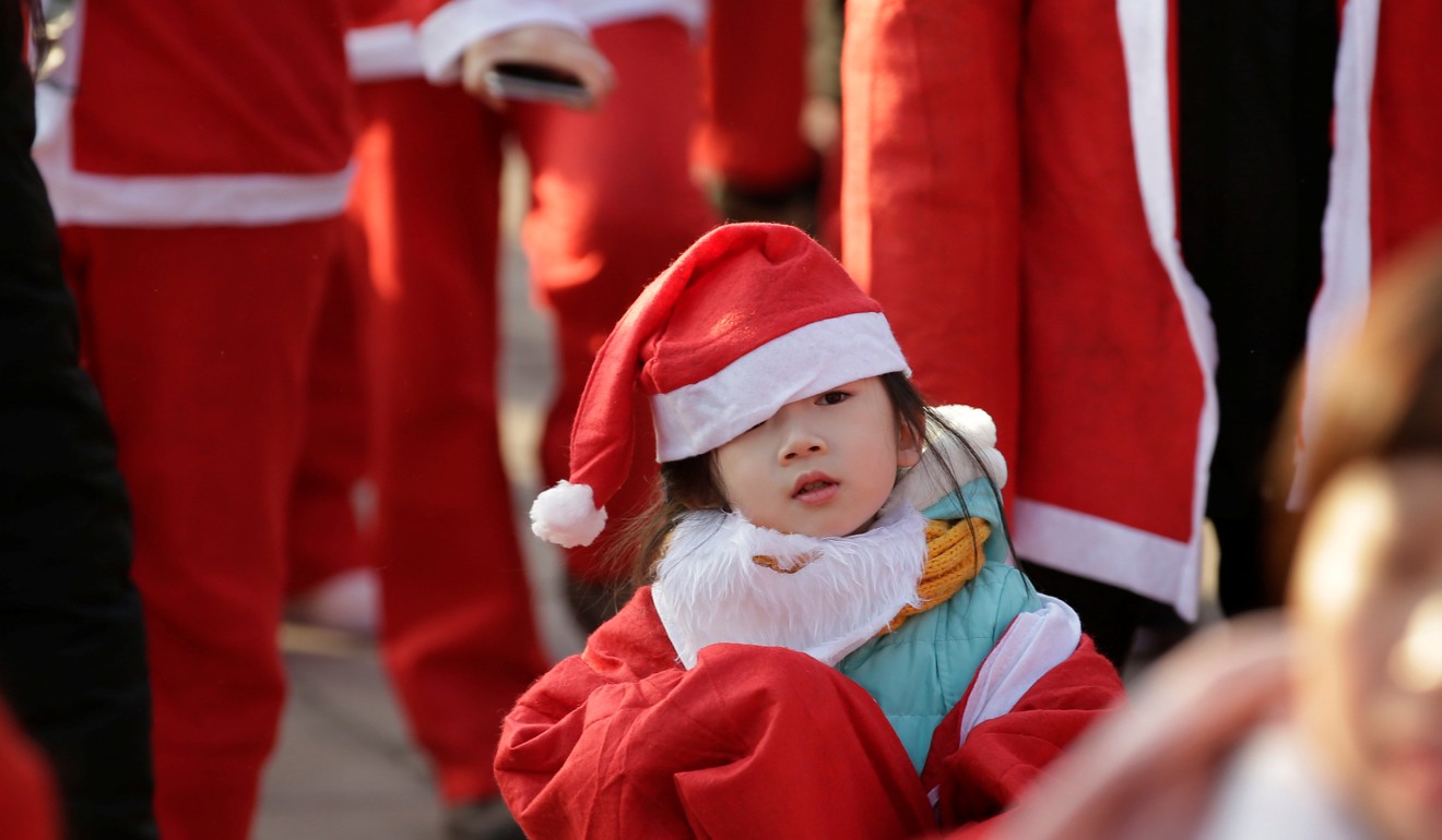 A girl dressed as a Santa Claus attends a Christmas fun run at Chaoyang Park in Beijing. Photo: Reuters