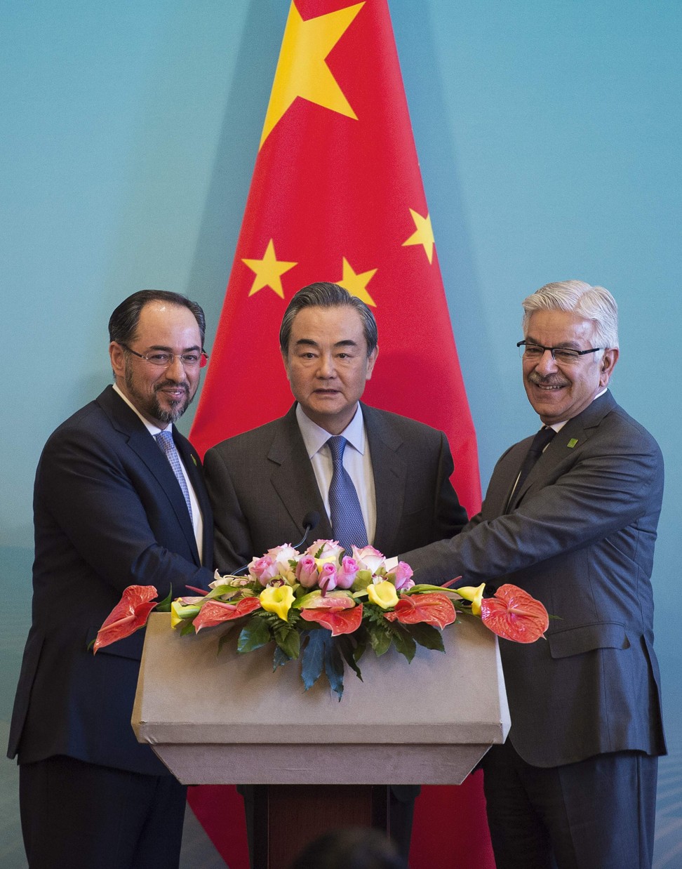 China's Foreign Minister Wang Yi (centre), Afghanistan's Foreign Minister Salahuddin Rabbani (left) and Pakistan's Foreign Minister Khawaja Muhammad Asif shake hands at the end of a joint press conference in Beijing. Photo: Agence France-Presse