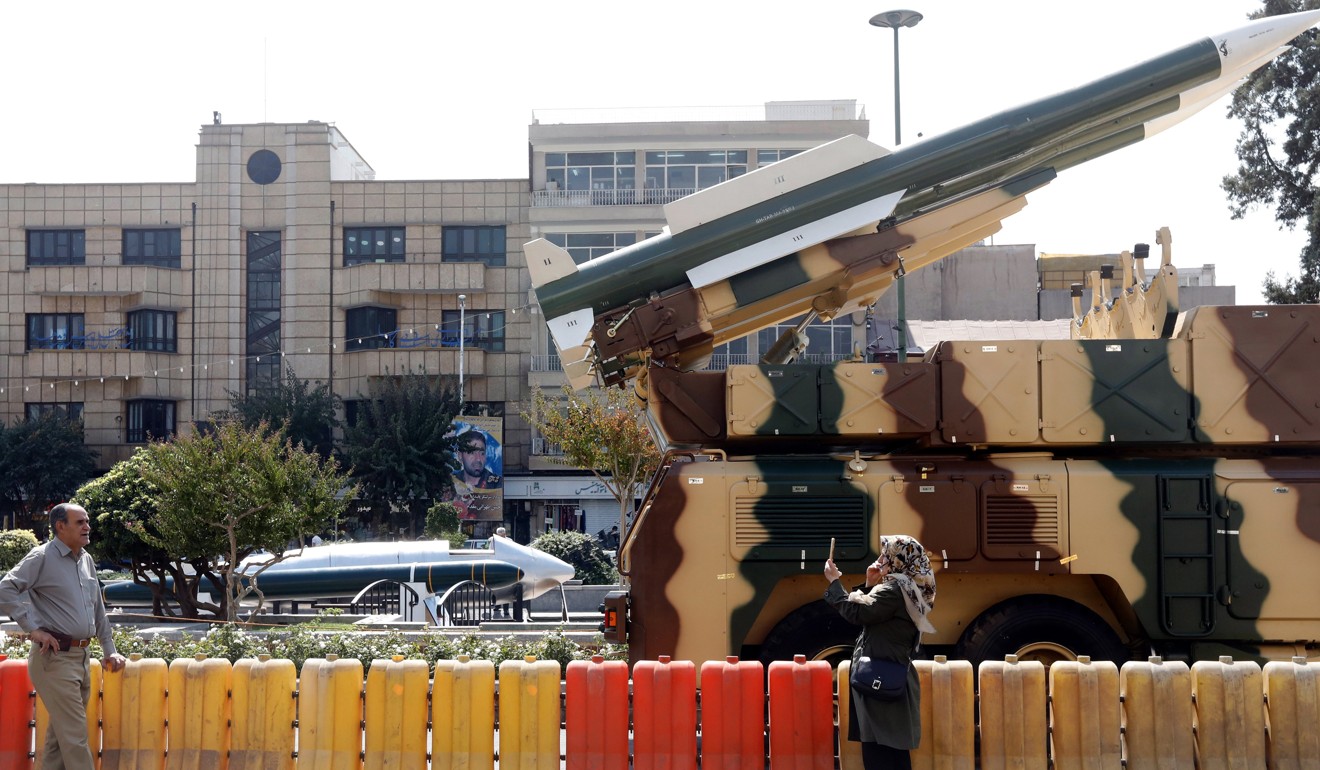 An Iranian woman takes a picture next to a medium range missile on display at Baharestan square, in Tehran, Iran. Photo: EPA-EFE
