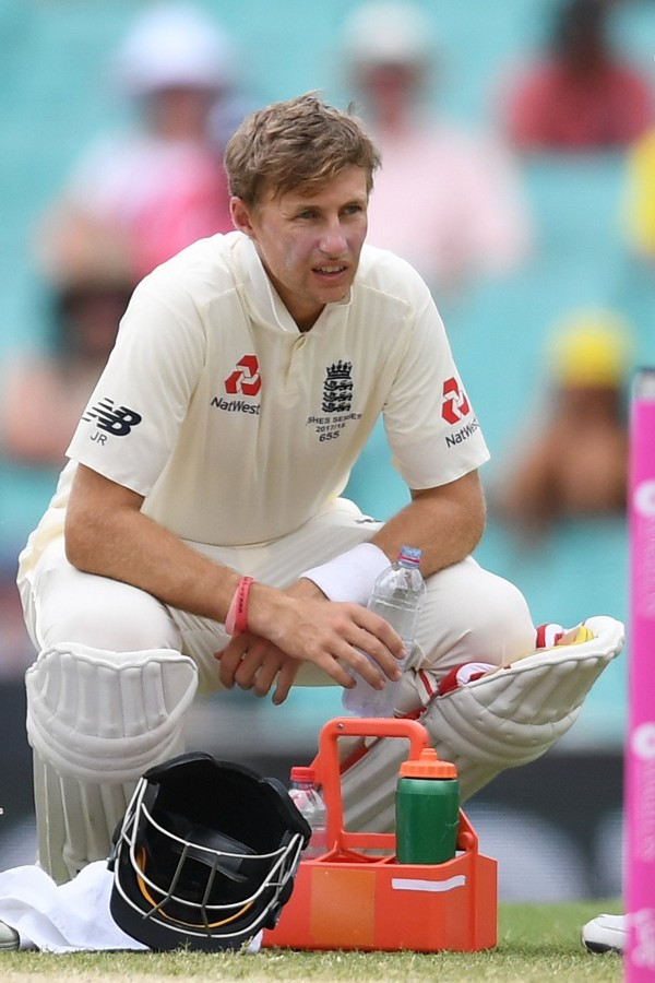 Root squats as he takes a drinks break before retiring ill. Photo: EPA