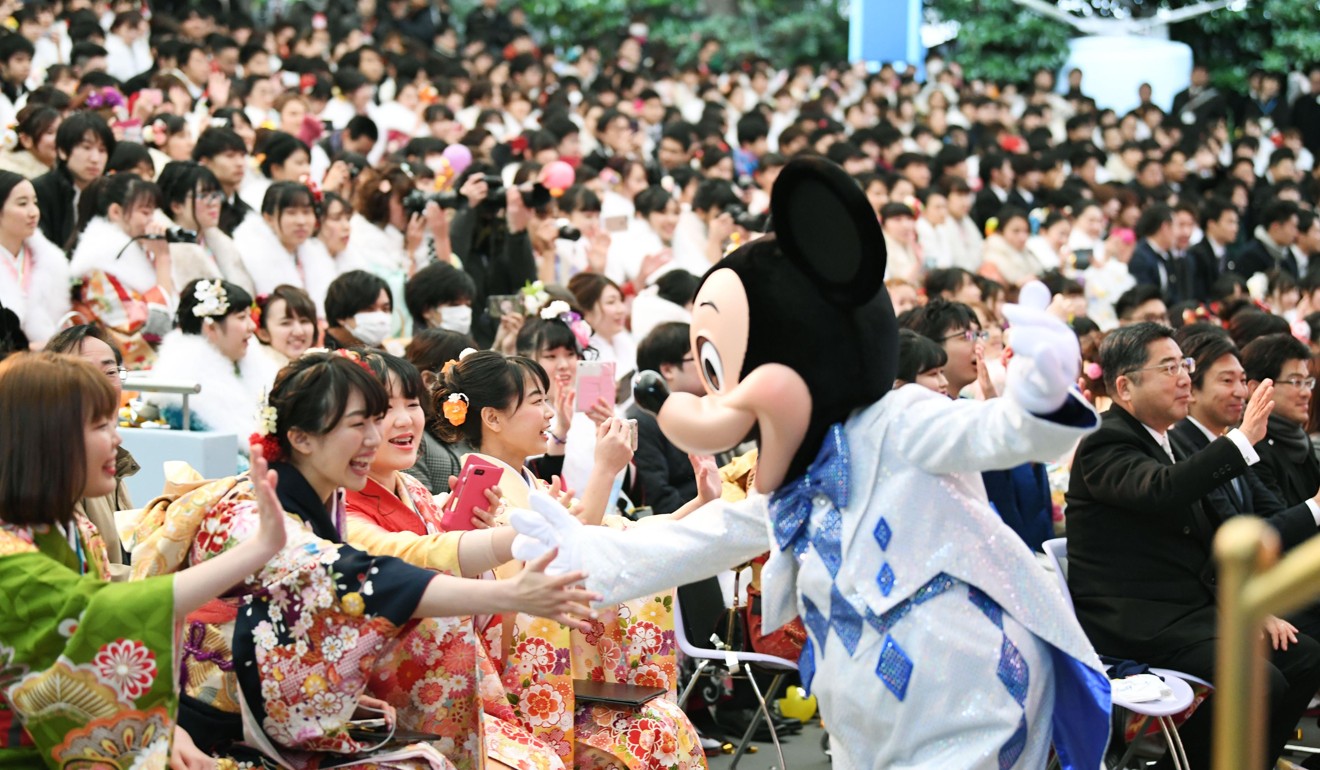 Mickey Mouse congratulates young women attending their Coming of Age Day ceremony at Tokyo Disneyland. Photo: Kyodo