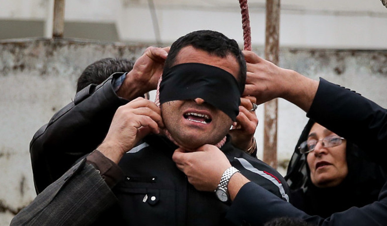 Relatives of murder victim Abdolah Hosseinzadeh, including his mother (right), remove the noose from Hosseinzadeh’s killer after deciding to grant clemency in 2014, in the city of Nowshahr. Photo: AFP