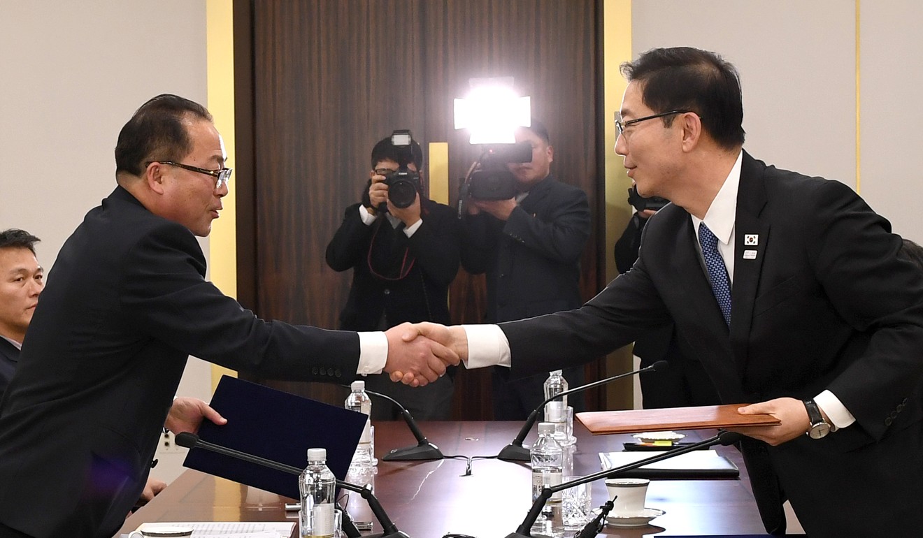 Chun Hae-sung (R, front), vice unification minister of South Korea, shakes hands with Jon Jong-su (L, front), vice-chairman of the Committee for the Peaceful Reunification of the Fatherland of the Democratic People's Republic of Korea (DPRK), at Peace House, a building in the South Korean side of Panmunjeom, on January 17, 2018. South Korea and the DPRK have agreed to jointly march at the opening ceremony of the South Korea-hosted Winter Olympics and to form a unified women’s ice hockey team. Photo: Xinhua