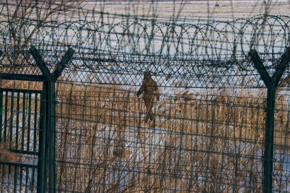 A North Korean soldier walks along the border fence in the North Korean town of Sinuiju opposite the Chinese city of Dandong. Photo: AFP