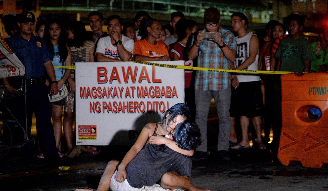 A woman hugs her husband who was shot dead by an unidentified gunman in Manila on July 23, 2016. Photo: AFP