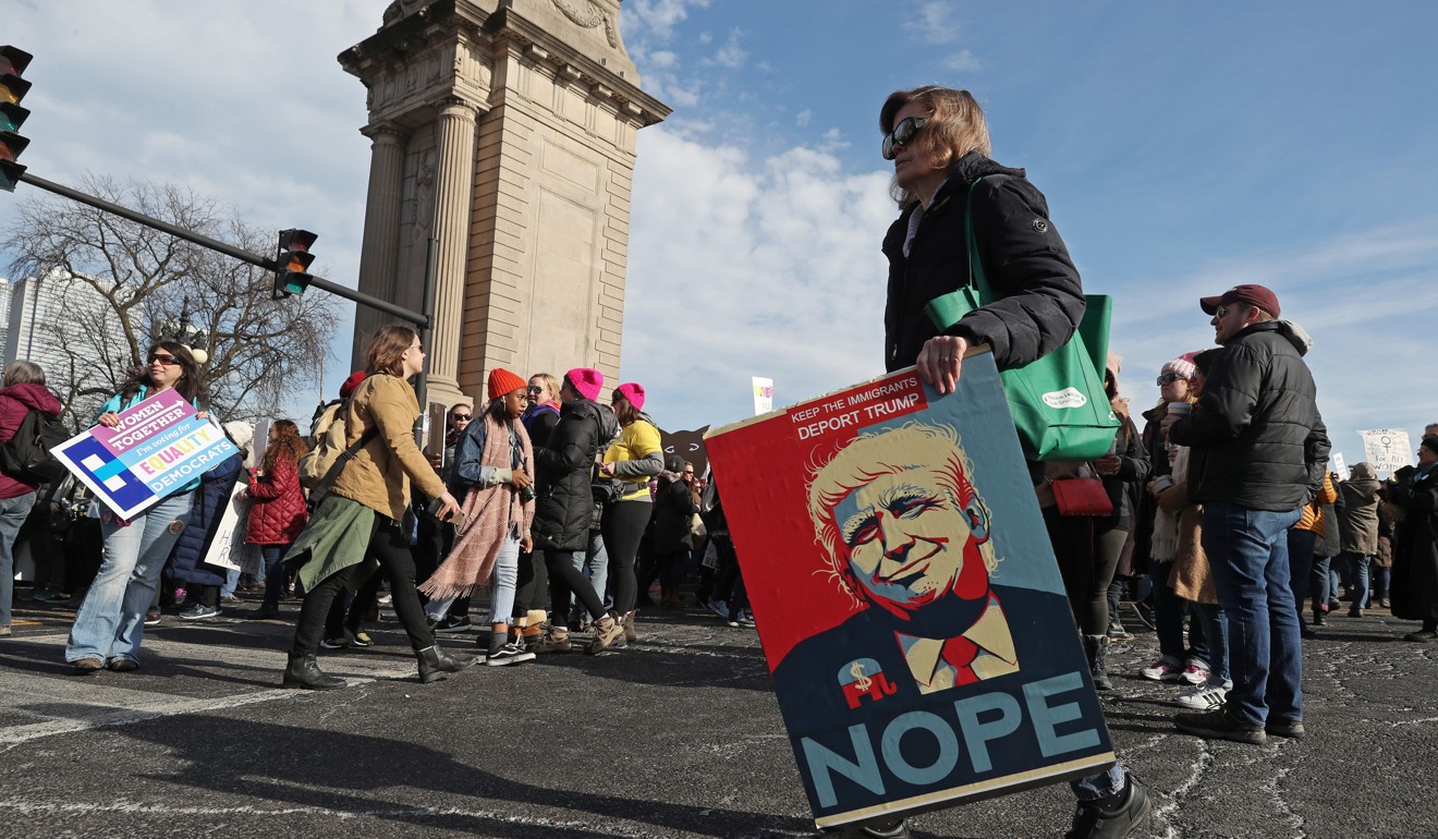 A women holds a poster depicting Donald Trump during the Women's March in Chicago. Photo: TNS
