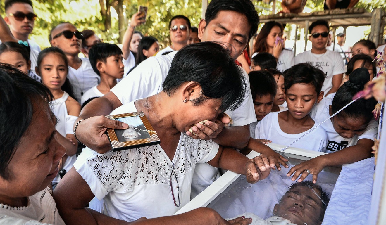 Relatives and friends mourn the death of a 15-year-old boy, who was a drug user and was shot by unidentified assailants in November as part of the country's war on drugs. Photo: EPA