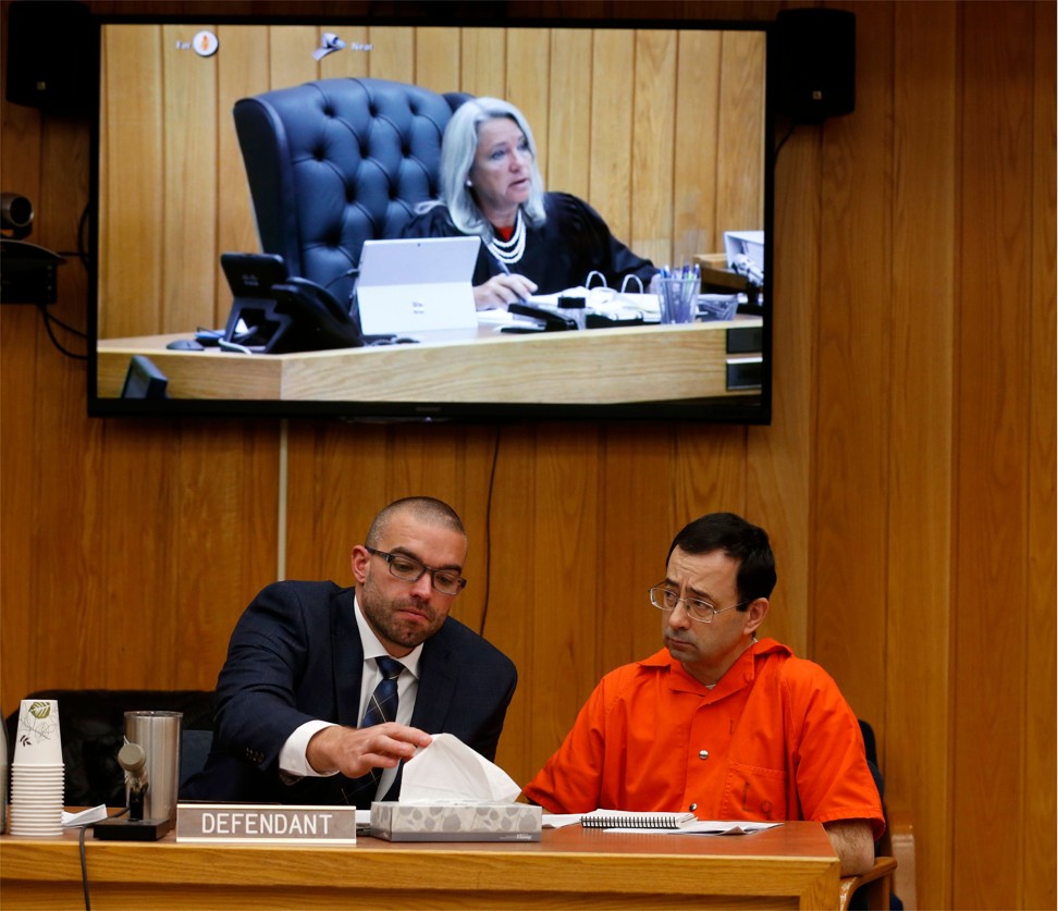 Eaton County Circuit Court Judge Janice Cunningham (seen on sceen) speaks as Nassar consults with his defense attorney Matt Newberg. Photo: AFP