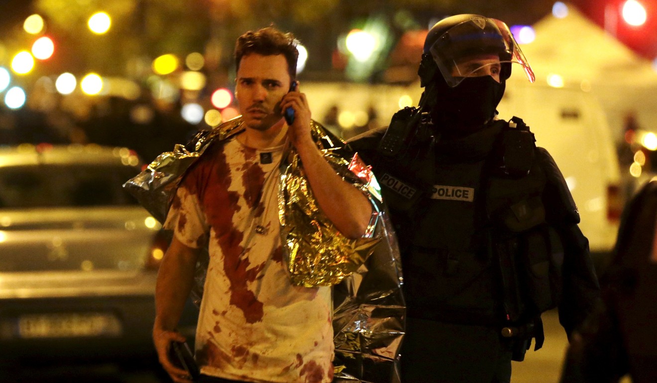 A French policeman assists a blood-covered victim near the Bataclan concert hall following attacks in Paris, France, November 14, 2015. Photo: Reuters