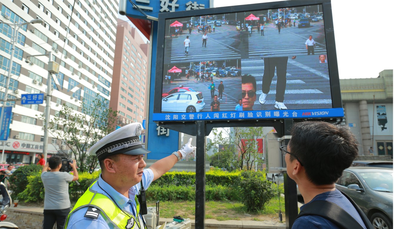 A traffic policeman shows a man that he has been facially identified while jaywalking the street in Shenyang, northeast China's Liaoning province. Photo: China Foto Press