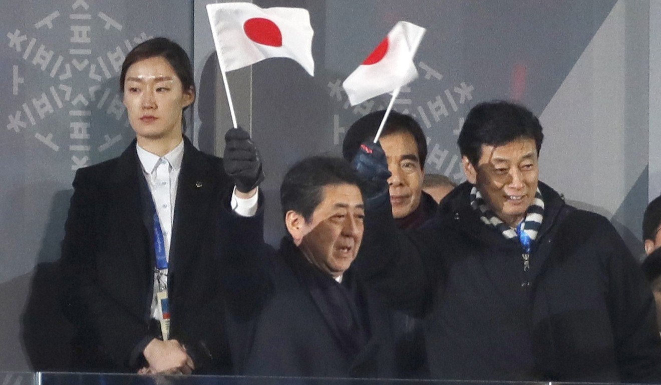 Shinzo Abe waving a flag during the ceremony. Photo: Reuters