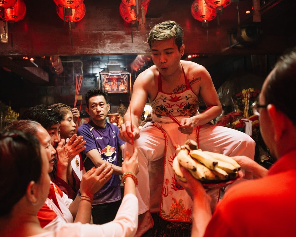 Arifin, possessed by the spirit of the Monkey King, Sun Wukong, gives out joss sticks to adherents. Photo: Muhammad Fadli