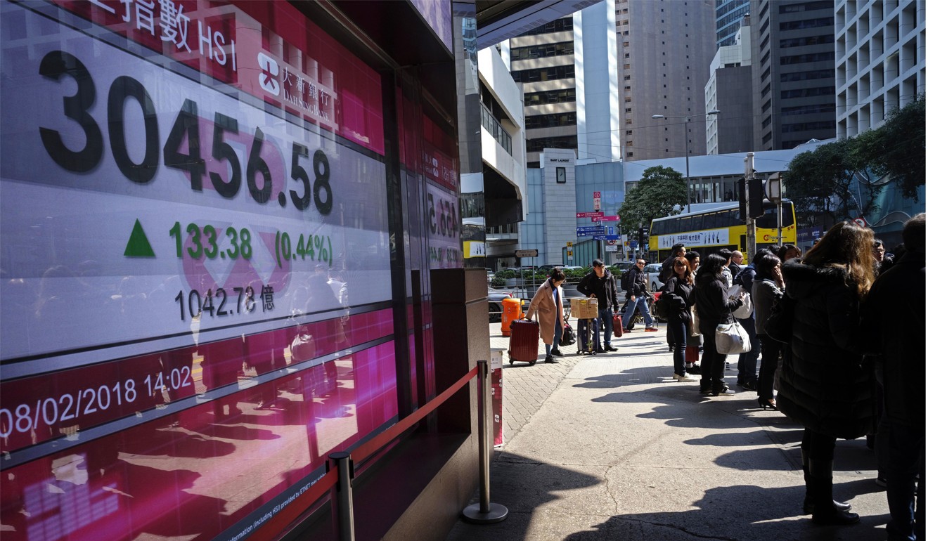 People walk past a bank electronic board showing the Hong Kong share index at Hong Kong Stock Exchange Thursday, Feb. 8, 2018. Asian stock markets were mixed Thursday with some benchmarks erasing early morning gains. Investors remained skittish after this week's financial turmoil and overnight losses on Wall Street. (AP Photo/Vincent Yu)