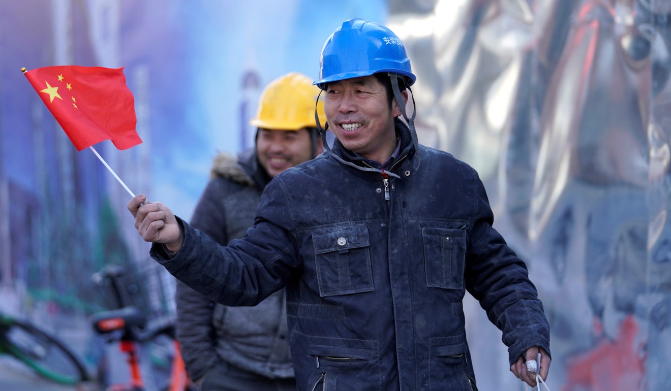 Workers outside a construction site in Beijing’s central business area on February 4. America is worried that the Chinese development model may one day replace the US model. Photo: Reuters