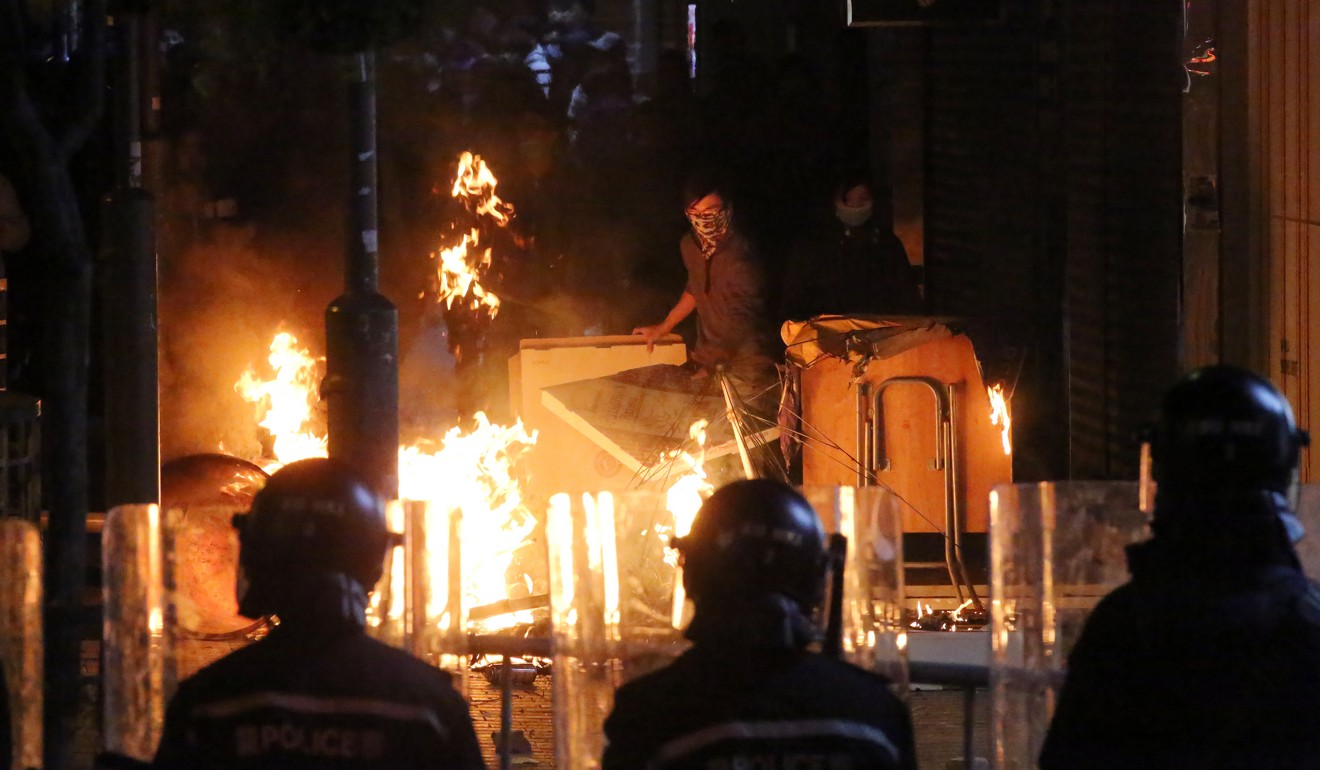 Police look on as rioters set fire in Mong Kok during the unrest. Photo: Edward Wong