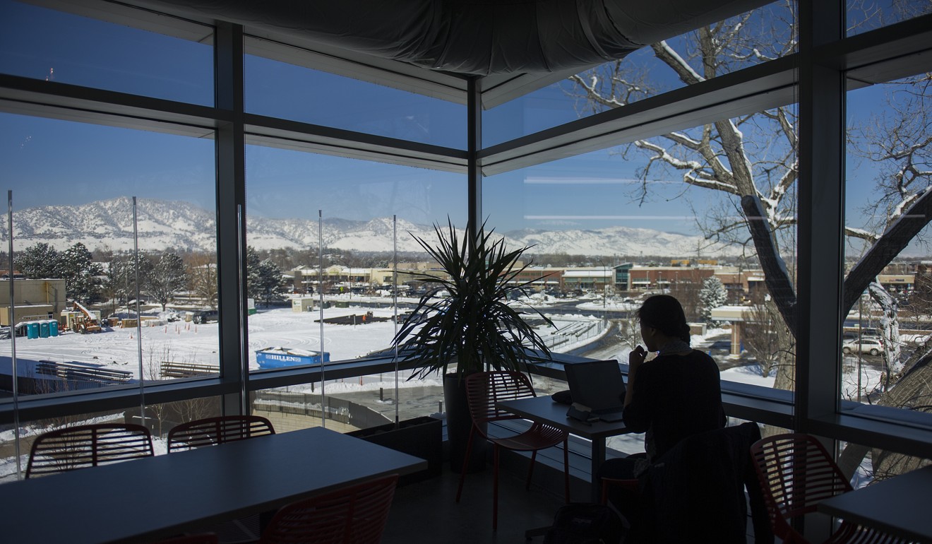 An employee works on a laptop computer as the Flatirons mountain range is seen out a window at the new Google campus in Boulder, Colorado. Photo: Bloomberg