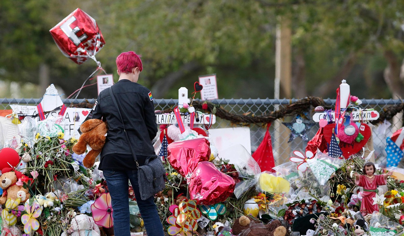 A Marjory Stoneman Douglas High School student stops to look at one of the memorials following their return to school in Parkland, Florida on February 28. Photo: AFP