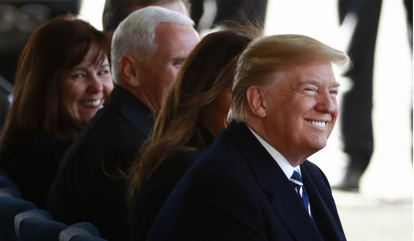 U.S. President Donald Trump smiles as he, first lady Melania Trump, Vice-President Mike Pence and his wife Karen attend the funeral service. Photo: Reuters