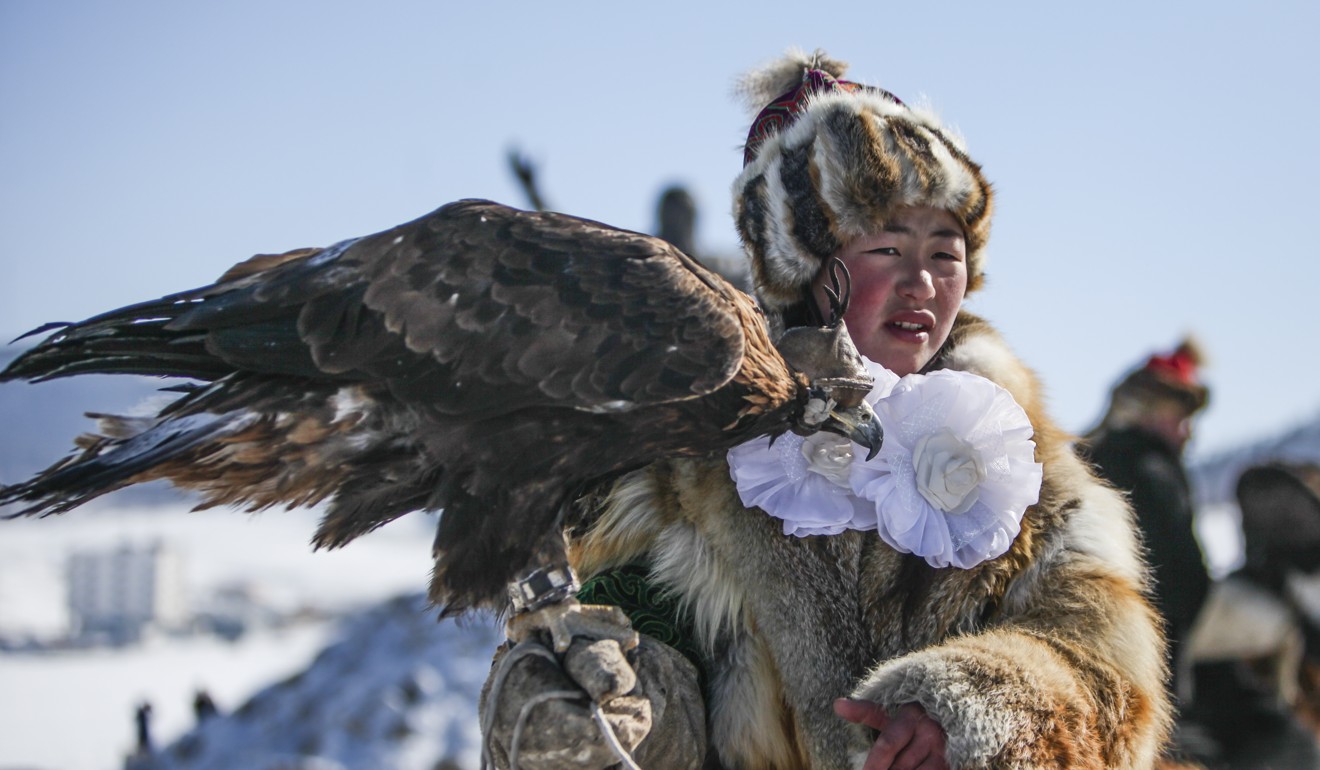 A hunter on horseback with her bird at the Spring Golden Eagle Festival. Only in the past 20 years have Kazakh families in Mongolia passed the eagle hunting tradition on to girls, not just boys. Photo: Anand Tumurtogoo