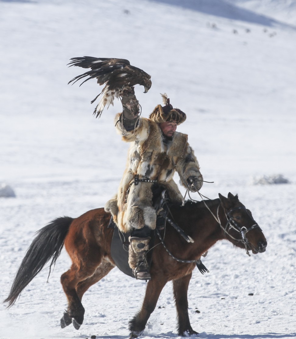 A hunter rides with his eagle at the Spring Golden Eagle Festival near the Mongolian capital. Photo: Anand Tumurtogoo