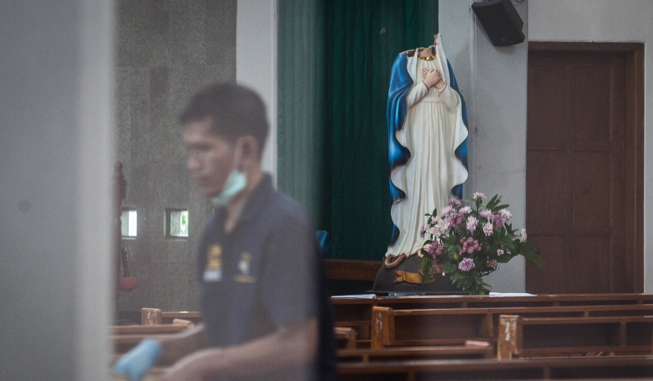 An Indonesian police investigator inspects the scene of an attack at the St. Lidwina Church in Sleman, Yogyakarta. Photo: EPA