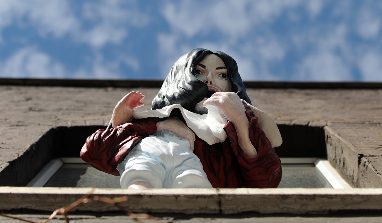 A statue in London called Madonna and Child depicts Michael Jackson dangling his baby son out of a window. Photo: AFP