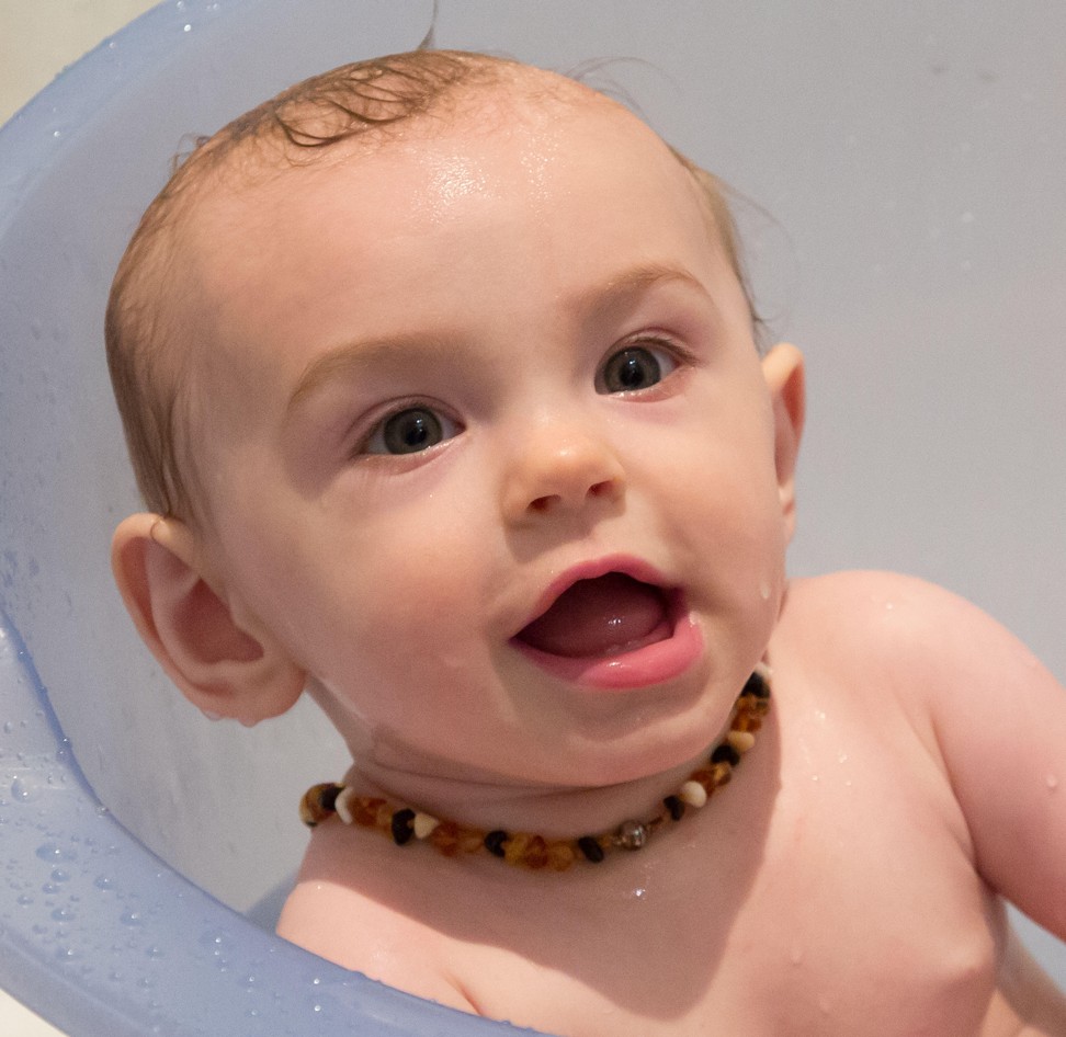A baby wears a teething necklace. Photo: Alamy