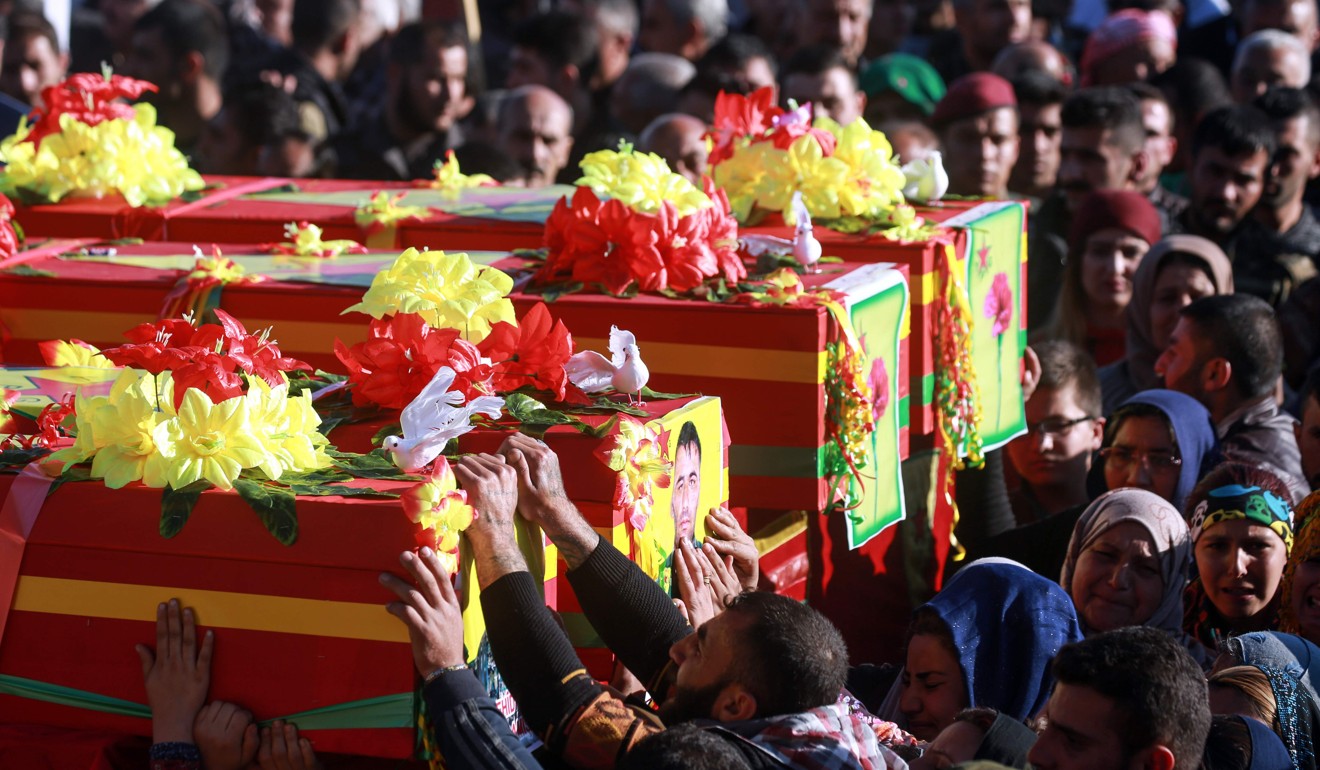 Syrian Kurds bid their farewell as they mourn by the coffins of People's Protection Units (YPG) fighters during their funeral in the northeastern city of Qamishli on March 17, 2018, after they were killed in combat in the Syrian border enclave of Afrin against the Turkish-led offensive. Photo: Agence France-Presse