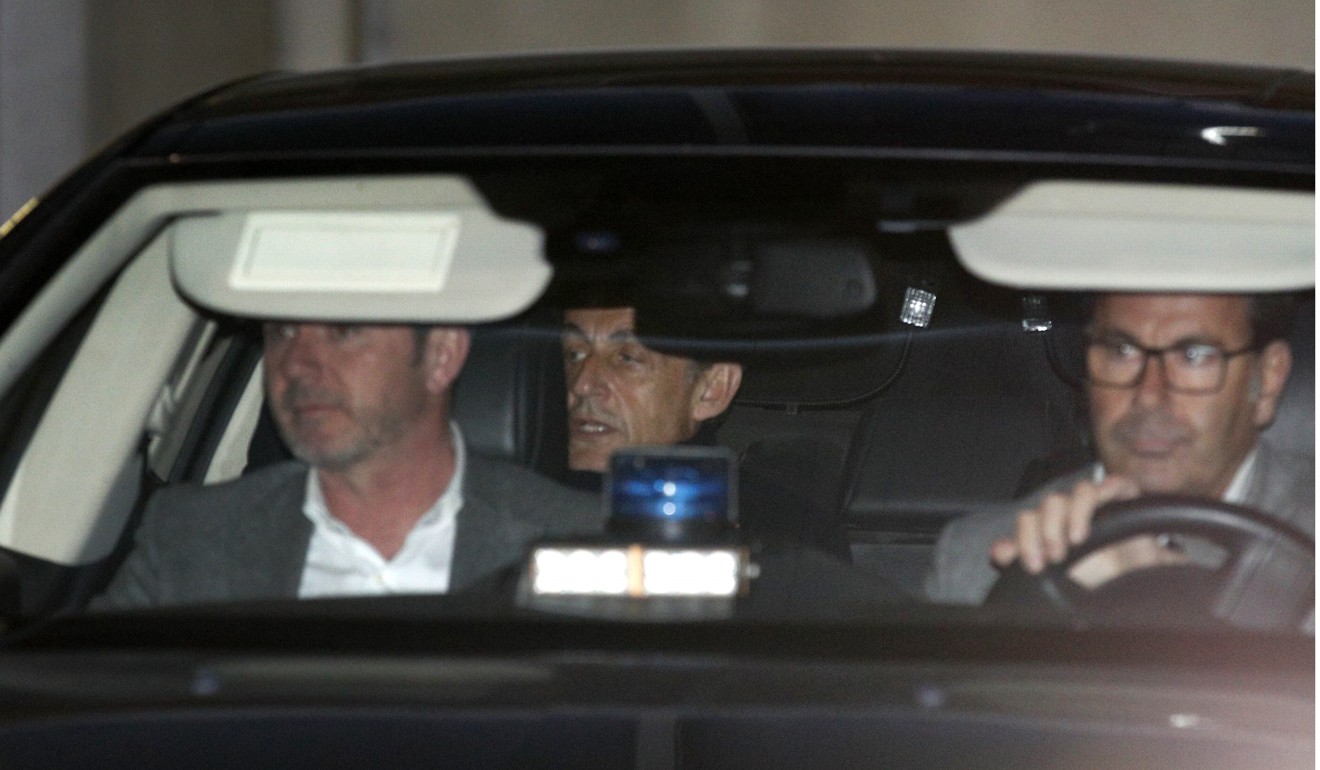 Former French president Nicolas Sarkozy, centre, leaves the police station where he was held, in Nanterre, outside Paris, on Wednesday. Photo: AP