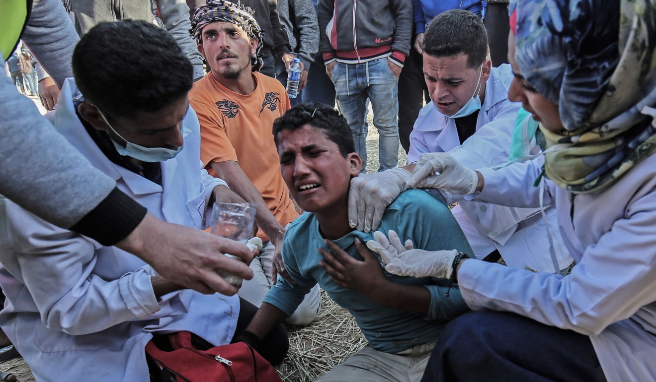 Medical staff help an injured Palestinian man during clashes with Israeli security forces. Photo: AFP