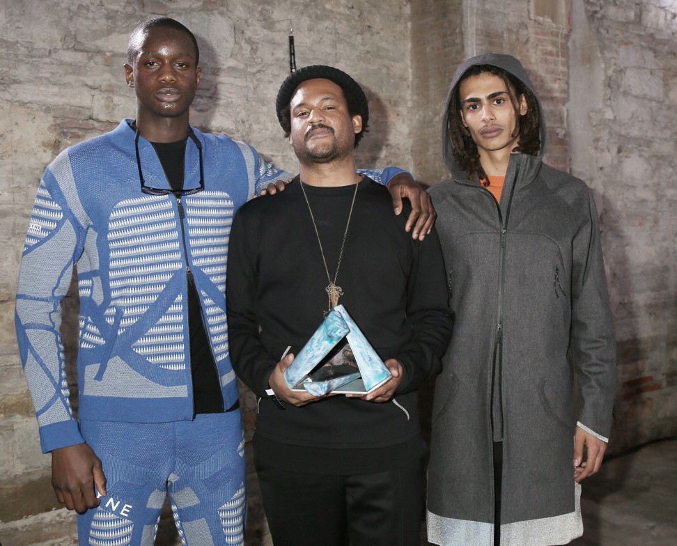 DYNE’s creative director, Christopher Bevans (centre), with the International Woolmark Prize Innovation Award. The brand is known for its NFC technology.