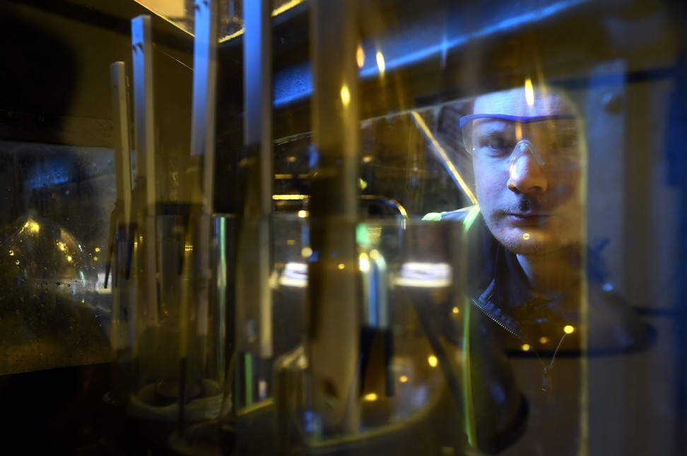 An employee monitors distillation in the Still House at the Auchentoshan Distillery near Glasgow, Scotland. Demand for more variety in Scotch whisky from fast-growing emerging markets and the request for lower alcohol varieties among health-conscious drinkers are challenging a closely guarded centuries-old tradition. Photo: AFP