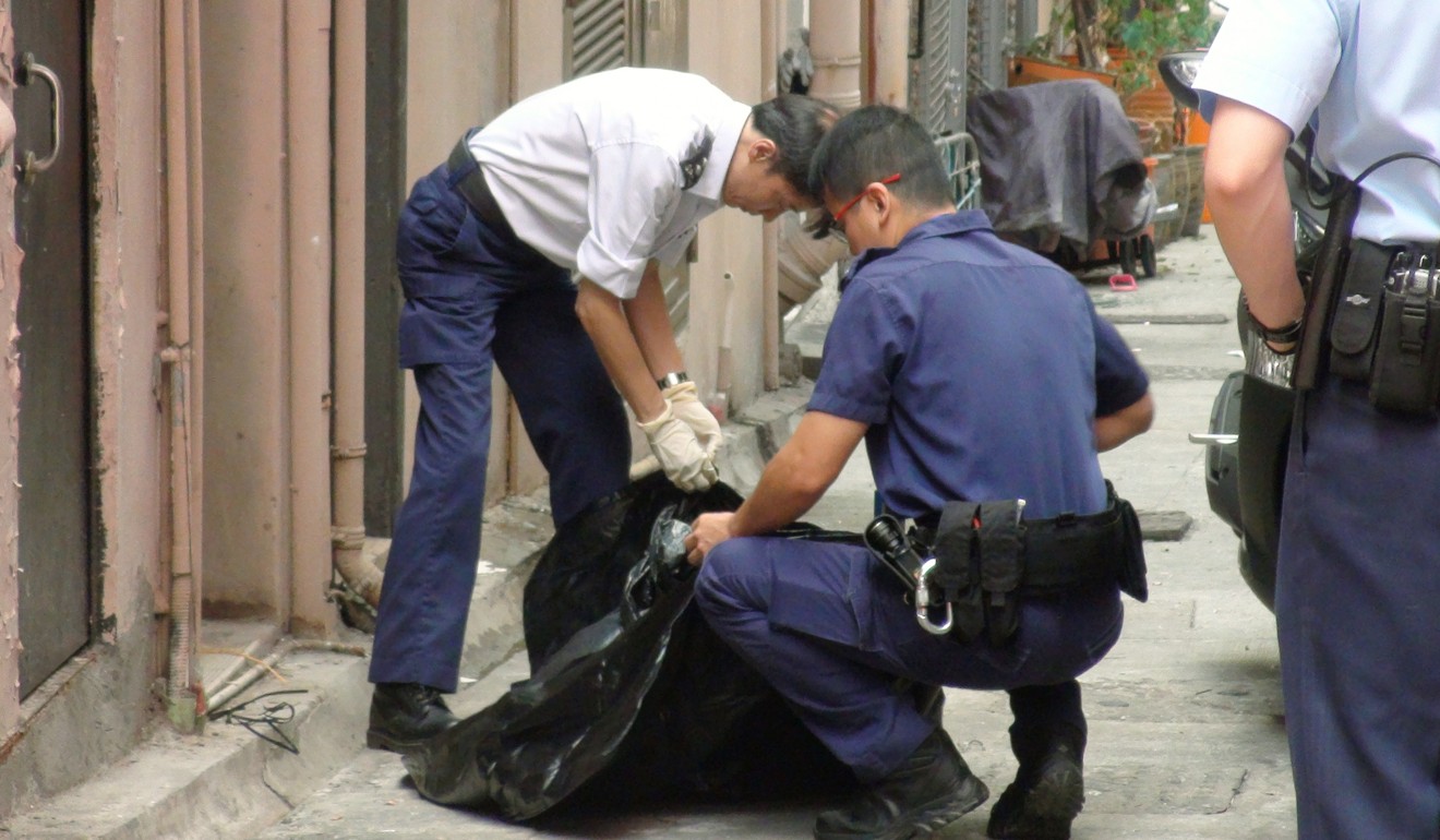 Police officers clean up after a dog was thrown off a building in Cheung Sha Wan. Photo: Handout