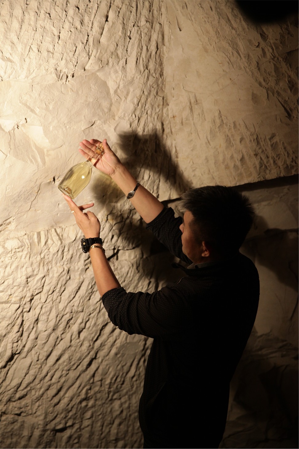 Liu Bolin holds a Ruinart bottle in the cellars.