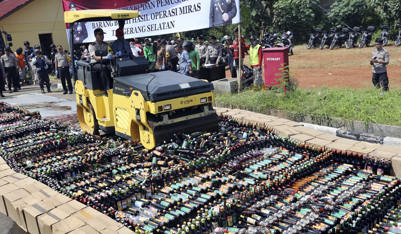 Police use a road roller to destroy bottles of illegal alcohol confiscated in Serpong, on the outskirts of Jakarta. Photo: AP