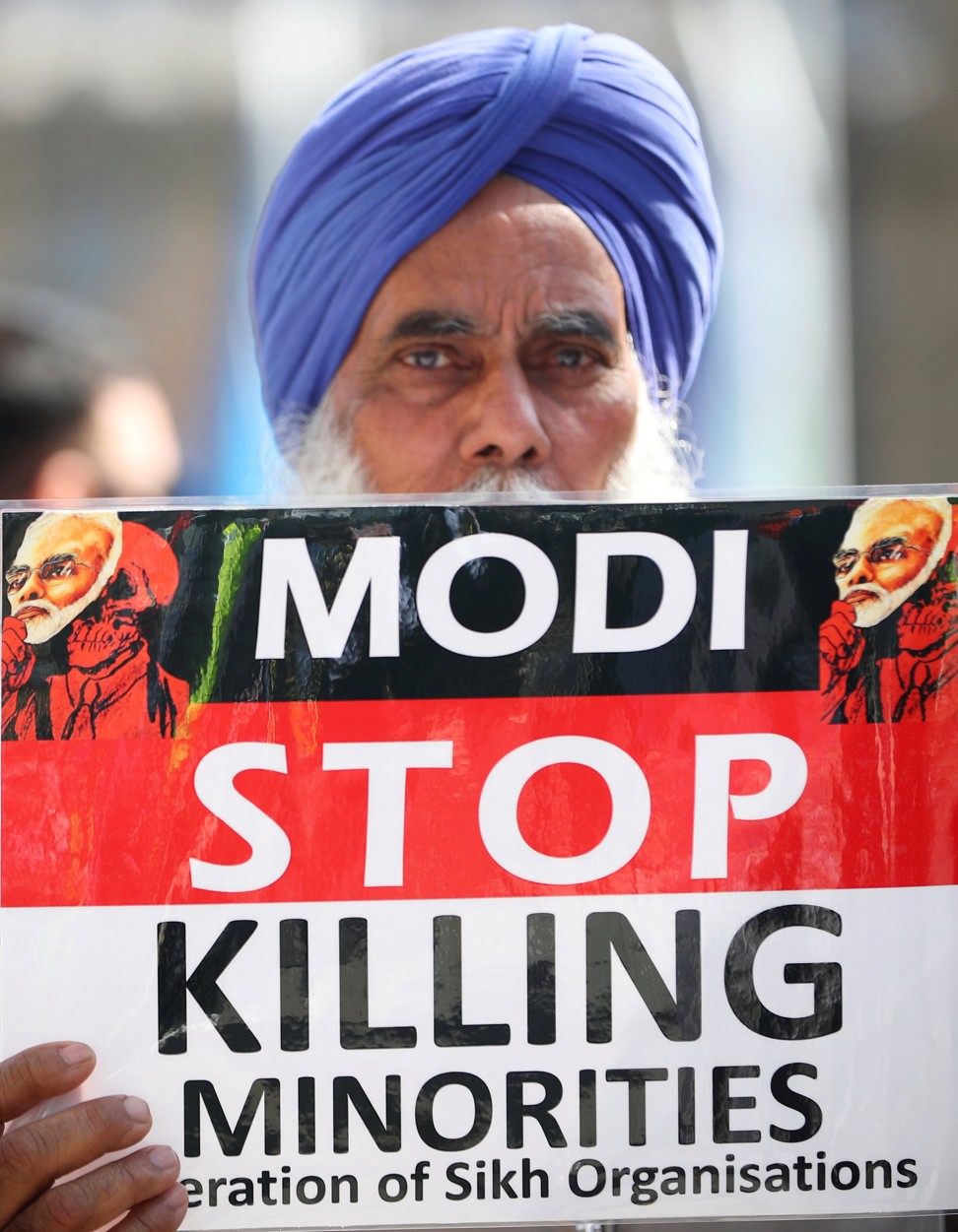A demonstrator holds a placard during a protest against the visit by India's Prime Minister Narendra Modi in Parliament Square, London. Photo: Reuters