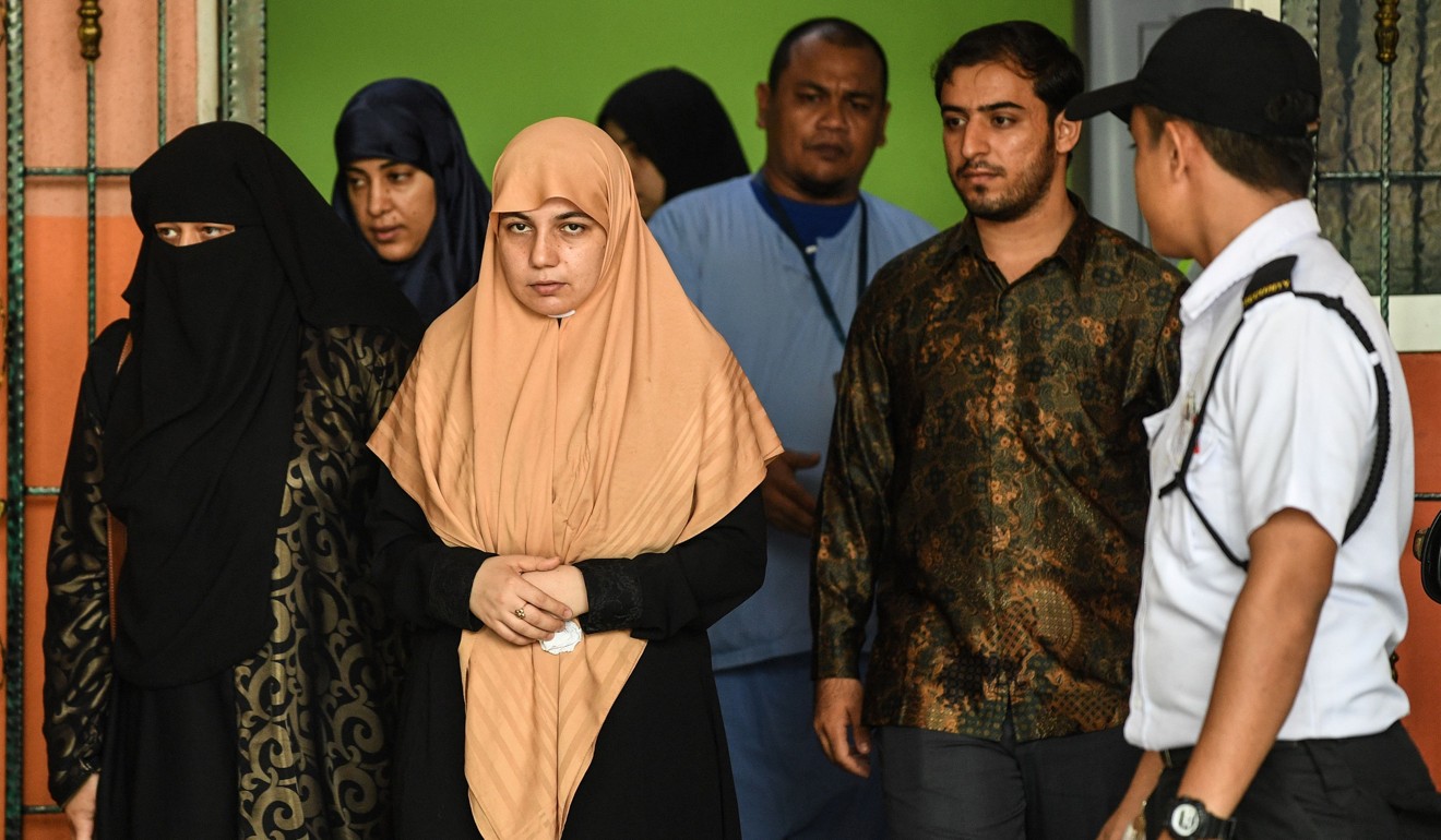 Enas al-Batsh (wearing orange) leaves the forensics wing of the Selayang Hospital in Kuala Lumpur on April 23, 2018. Photo: AFP