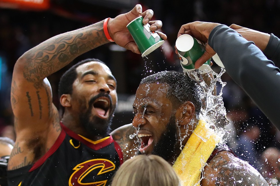 LeBron James is showered with Gatorade by teammate JR Smith while being interviewed after the Cavs’ 98-95 win. Photo: AFP