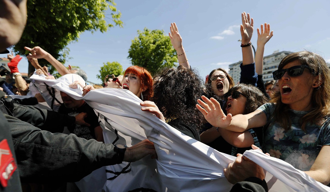 Police at the entrance of the Justice palace in Pamplona, Spain, try to control angry demonstrators Thursday after the sentencing hearing of five men accused of raping an 18-year-old woman during the 2016 San Fermin festival. Photo: EPA