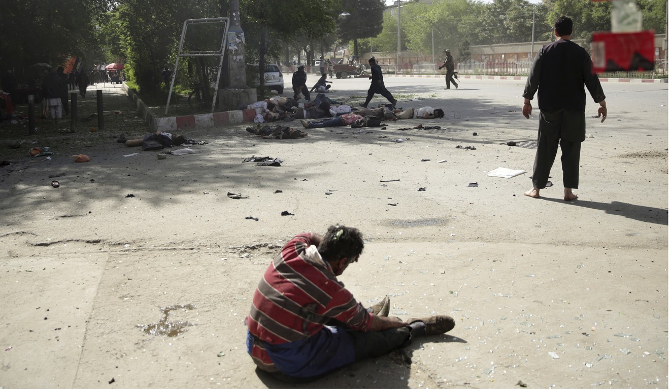 A wounded man sits on the ground after explosions in Kabul. Photo: AP