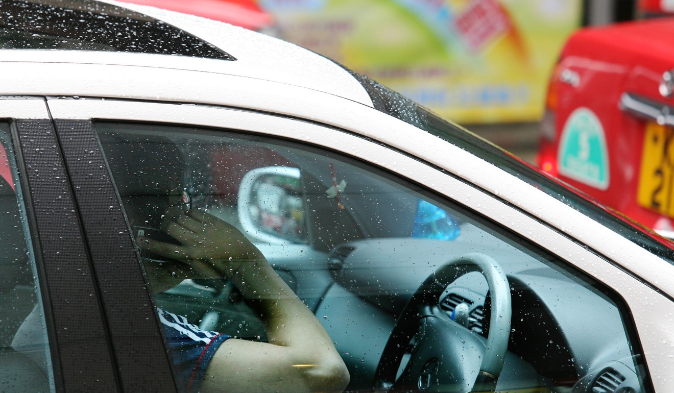 Talking on the phone while driving is a crime. Photo: Martin Chan