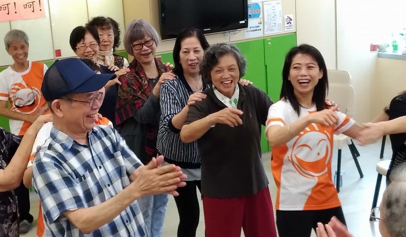Hermia Chow (right, in orange T-shirt) with laughter yoga participants. Photo: Handout